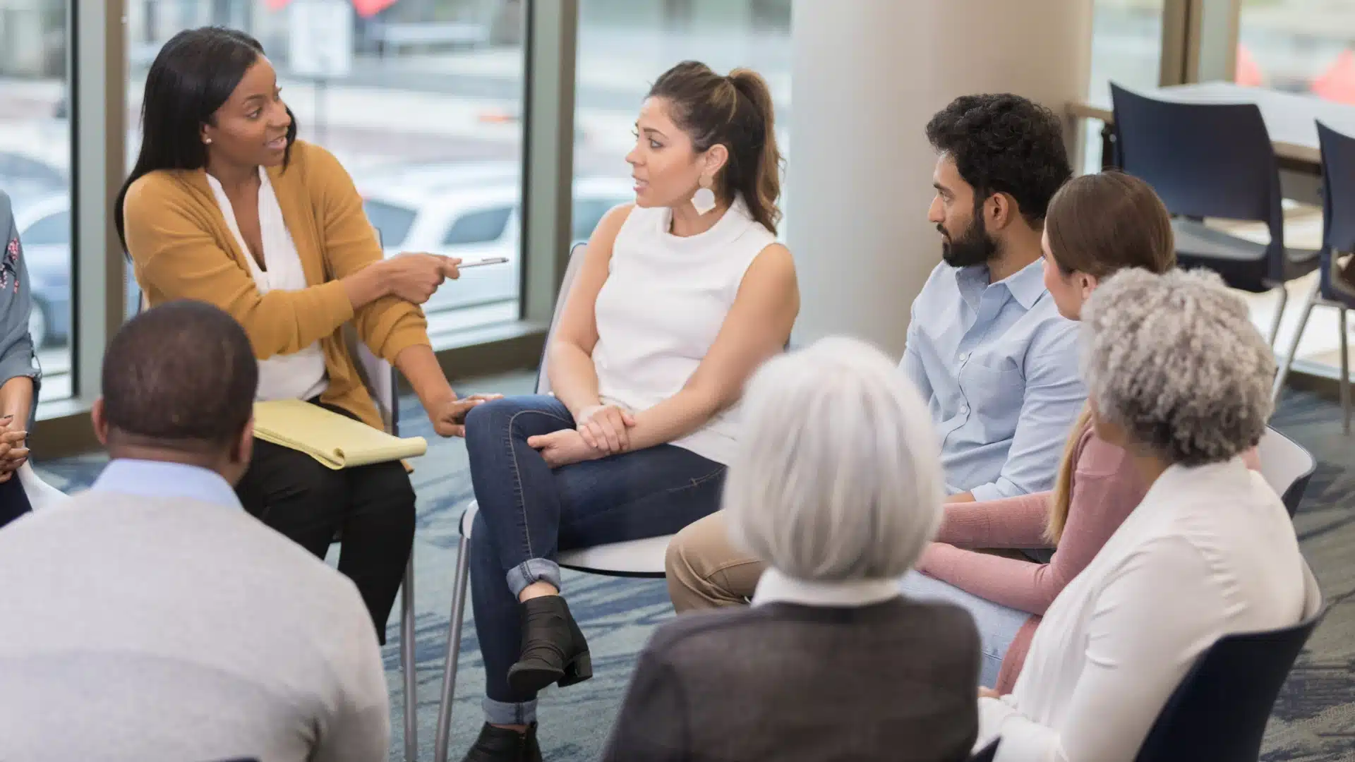 Group of people in a therapy session, sitting together and talking