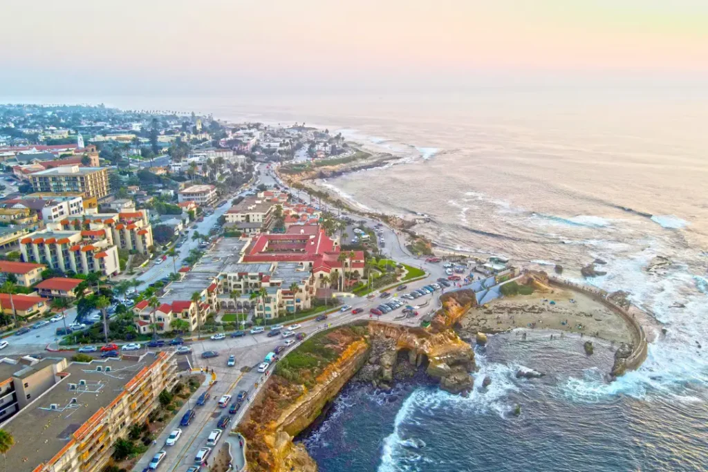 Calm coastal view of La Jolla Cove with person standing and looking at ocean while feeling overwhelmed emotionally
