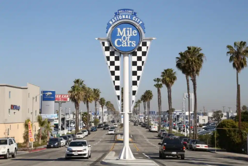 A street sign displaying the phrase "Mile Cars," indicating a distance or location related to vehicles.
