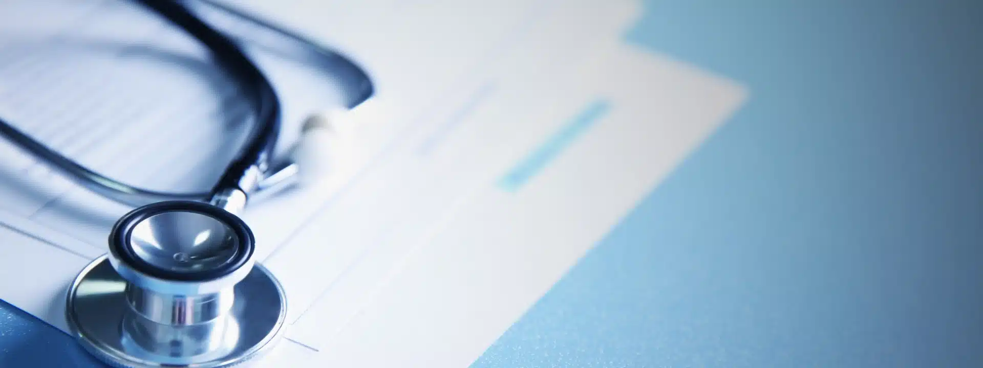 Close-up of a stethoscope resting on medical documents.