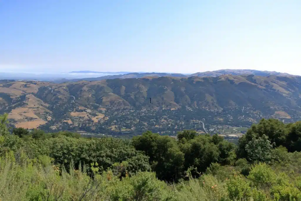 Lush green mountains under a clear blue sky, showcasing the beauty of nature and vibrant vegetation.